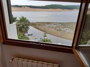 una ventana con vistas a una masa de agua en Santander Mogro en Mogro