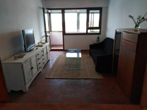 a living room with a couch and a television at Santander Mogro in Mogro