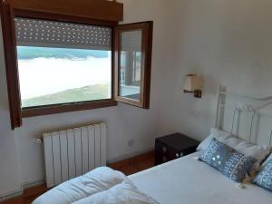 a bedroom with a bed and a large window at Santander Mogro in Mogro