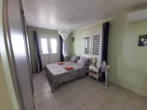 Un dormitorio con una cama y una mesa. en Villa Sirius vue sur mer en Le Vauclin