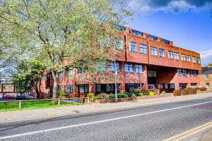 un edificio de ladrillo rojo al lado de una calle en The Landmark, Lutons best location, en Luton