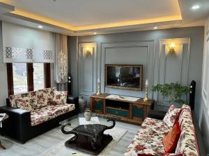 a living room with a couch and a tv at Greenland Villa Premium 61 in Trabzon