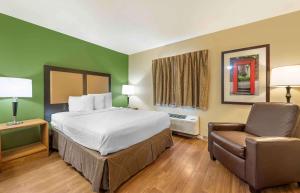 a hotel room with a bed and a chair at Extended Stay America Select Suites - Indianapolis - North - Carmel in Carmel