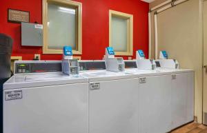 a row of washing machines in a room with a red wall at Extended Stay America Select Suites - Indianapolis - North - Carmel in Carmel +19 photos