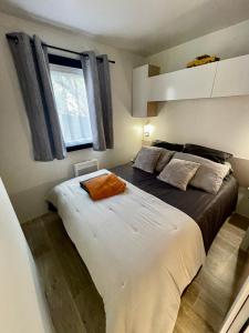a bedroom with a large bed and a window at Tiny house famille nature cap ferret in Claouey