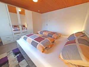a bedroom with two beds and a mirror at Landhaus Christina in Rumbach