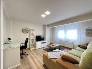 sala de estar con sofá y escritorio en Amplio apartamento con terraza en Bouzas, cerca de la playa., en Vigo
