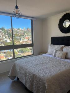 1 dormitorio con cama grande y ventana grande en Apartamento nuevo en Centro de Viña del Mar, Parque Urbano, en Viña del Mar