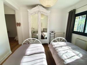 1 dormitorio con 2 camas y un espejo grande en Villa Côte d'Azur piscine privée, en La Gaude