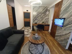 sala de estar con sofá, mesa y TV en Square Luxury Apartments en Berovo
