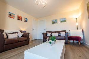 uma sala de estar com um sofá e uma mesa em Serene Sands em Felixstowe