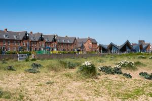 a row of houses in a field with flowers at Serene Sands in Felixstowe