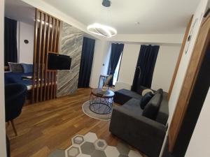 a living room with a couch and a tv at Square Luxury Apartments in Berovo