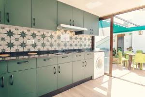 a kitchen with green cabinets and a washer and dryer at Charming Nerja Hostel in Nerja