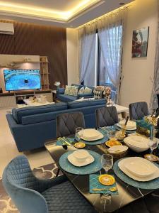 sala de estar con sofá y mesa con sillas en Elite Apartment 2, en Riad