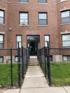 a fence in front of a brick building at Modern 3 Bedroom Close to Downtown Chicago in Chicago