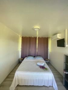 Un dormitorio con una gran cama blanca con flores. en Temana Airport Faa'a,Tahiti en Faaa
