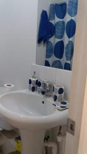 baño con lavabo y jarrones azules y blancos en Departamento Ciudad del Encanto, en Ovalle