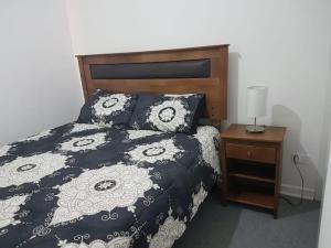 un letto con piumone bianco e nero e comodino di Departamento Ciudad del Encanto a Ovalle