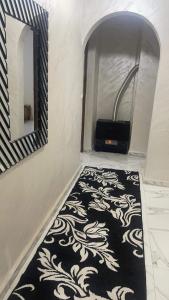 a bathroom with a black and white rug and a mirror at Très belle appartement in Constantine