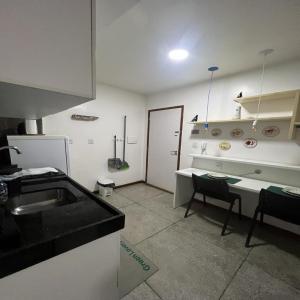 a kitchen with a sink and a table and a counter at STUDIO 306 | WIFI 600MB | RESIDENCIAL JC, um lugar para ficar. in Belém