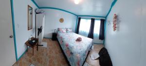 sypialnia z łóżkiem w pokoju z niebieskimi ścianami w obiekcie Aitutaki Budget Accommodation w mieście Amuri