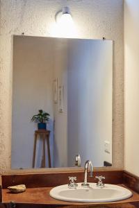 baño con lavabo y espejo grande en Posada del Paraíso-Exclusivo adultos en Las Rabonas