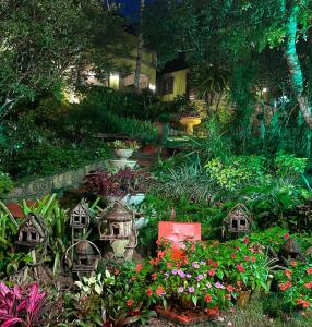 a garden with birdhouses and flowers in a yard at Cedros Pousada in Guaramiranga