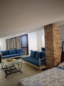 a living room with blue couches and a brick wall at Apartments Simovic in Tivat