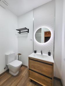 y baño con aseo, lavabo y espejo. en Precioso estudio con dos ambientes, en Madrid