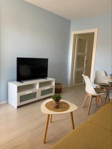 a living room with a flat screen tv and a table at Popi in Budva