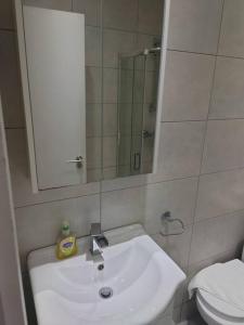 a bathroom with a sink and a mirror and a toilet at Southwark & Bermondsey nest Penthouse apartment in London