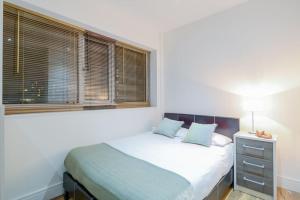 a bedroom with a bed and a window at Southwark & Bermondsey nest Penthouse apartment in London