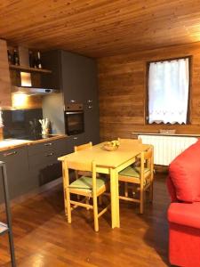 - une cuisine avec une table et des chaises dans la chambre dans l'établissement Appartamento ampio giardino adiacente piste sci 4/6 posti letto, à La Thuile