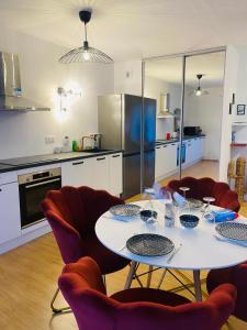 een keuken met een tafel en stoelen en een keuken met een koelkast bij Lisandrina in Ajaccio