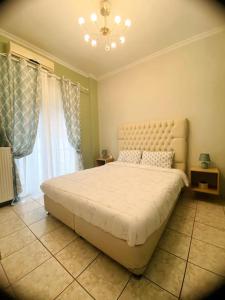 Un dormitorio con una cama grande y una lámpara de araña. en Comfort and relaxation, en Pireo