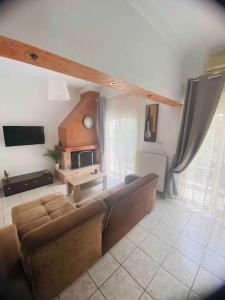 een woonkamer met een bank en een tv bij Comfort and relaxation in Piraeus