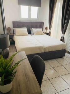 een slaapkamer met een groot bed met een tafel en een tafel aan de zijkant bij Comfort and relaxation in Piraeus