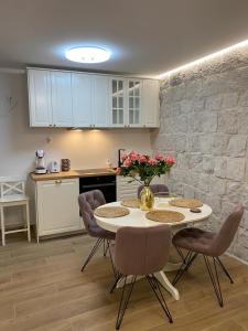 uma cozinha com mesa e cadeiras com flores em Garma em Slatine
