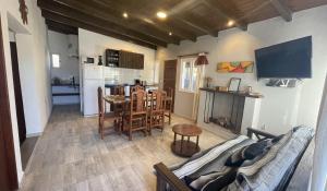 Il comprend un salon et une cuisine avec un canapé et une table. dans l'établissement Hermosa casa en Tafí del Valle!, à Tafí del Valle