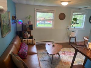 uma sala de estar com um sofá de couro e uma mesa em Boho-Chic Studio - Unit 1 em Bloomington