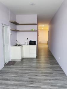 a kitchen with white cabinets and a hardwood floor at MersingFirstFloor丰盛港二楼民宿 in Mersing