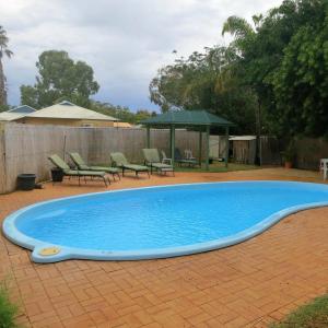 uma grande piscina azul num quintal em Kalbarri Inn em Kalbarri