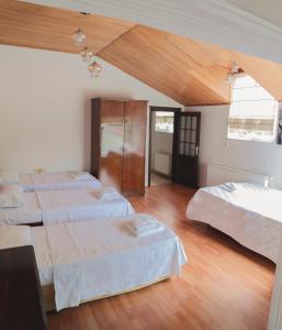 a large room with three beds and wooden floors at DES VILLA Trabzon in Trabzon