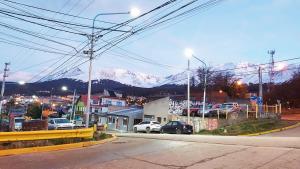 una ciudad con montañas cubiertas de nieve en el fondo en Castor Fueguino: departamento cálido, céntrico y equipado - Wi Fi en Ushuaia