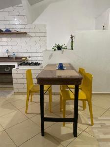 une table et quatre chaises jaunes dans une cuisine dans l'établissement Apartamento próximo ao Aeroporto de Florianópolis, à Florianópolis