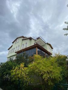 une grande maison au sommet d'une colline avec des arbres dans l'établissement DES VILLA Trabzon, à Trabzon