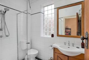 a bathroom with a sink and a toilet and a mirror at City Edge Home From Home in Keswick +27 photos