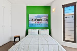 une chambre avec un lit blanc et un mur vert dans l'établissement 2 bedrooms 2 baths with balcony and ocean views, across from ocean, à Alexandra Headland 6 autres photos