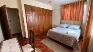 een slaapkamer met een bed en een grote houten kast bij Departamento independiente centrico in Cochabamba